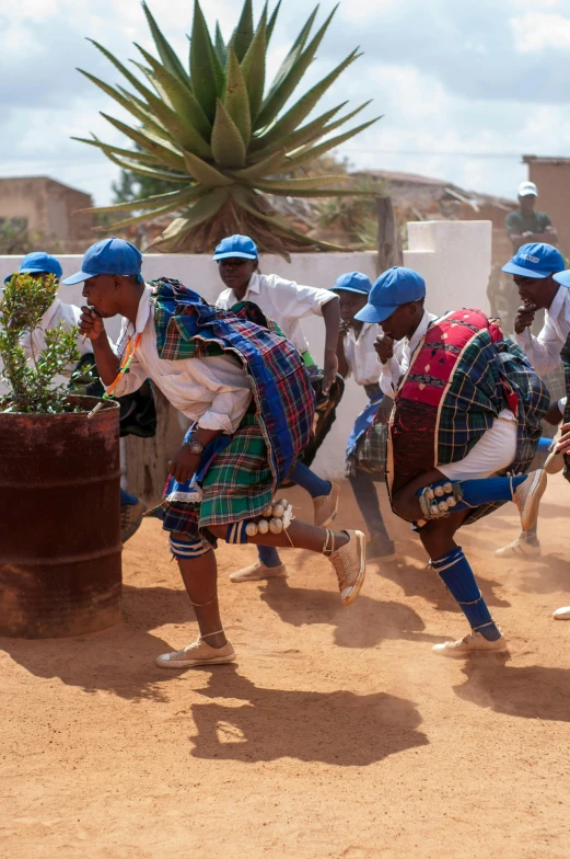 african dance performers are dancing near the dirt