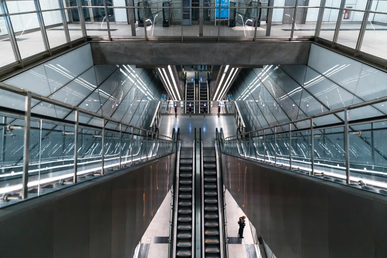 people are walking up and down escalators in an airport