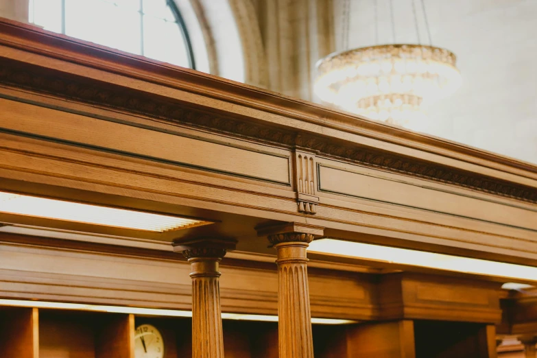 a view of columns and bookcases with a clock in the background