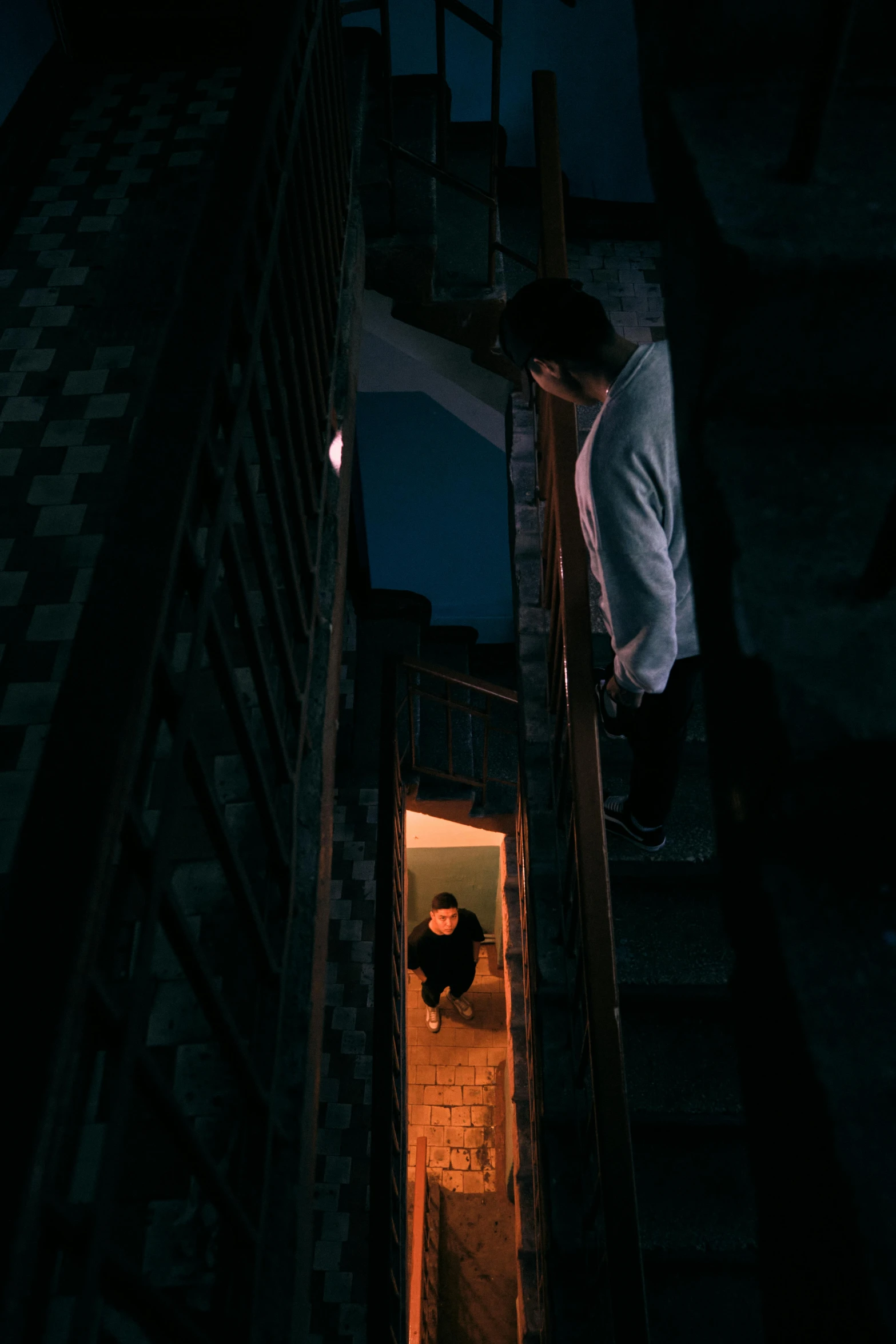 a person standing on a flight of stairs with a lit up window in the middle