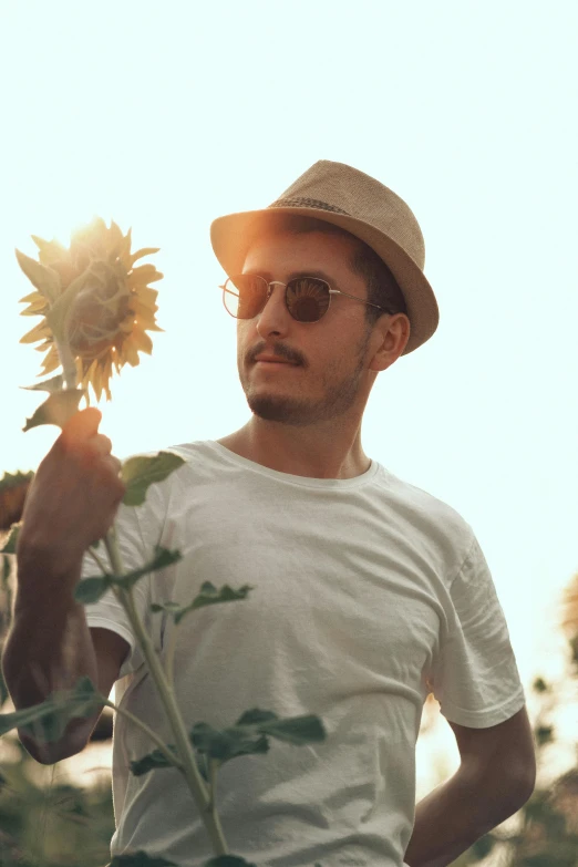 a man holding a sunflower with his hands