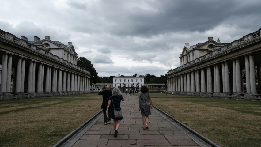 people are walking together down a walkway in an empty park