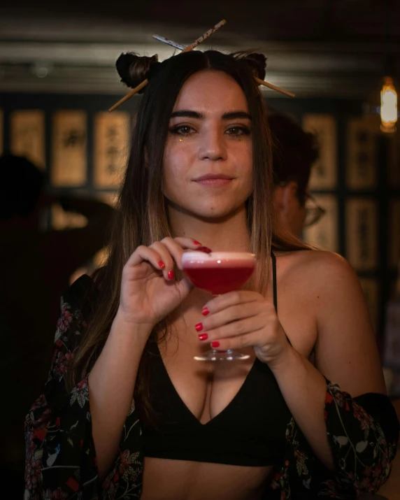 a women is holding a martini with her left hand