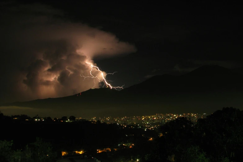lightning is hitting the mountains during a nighttime view