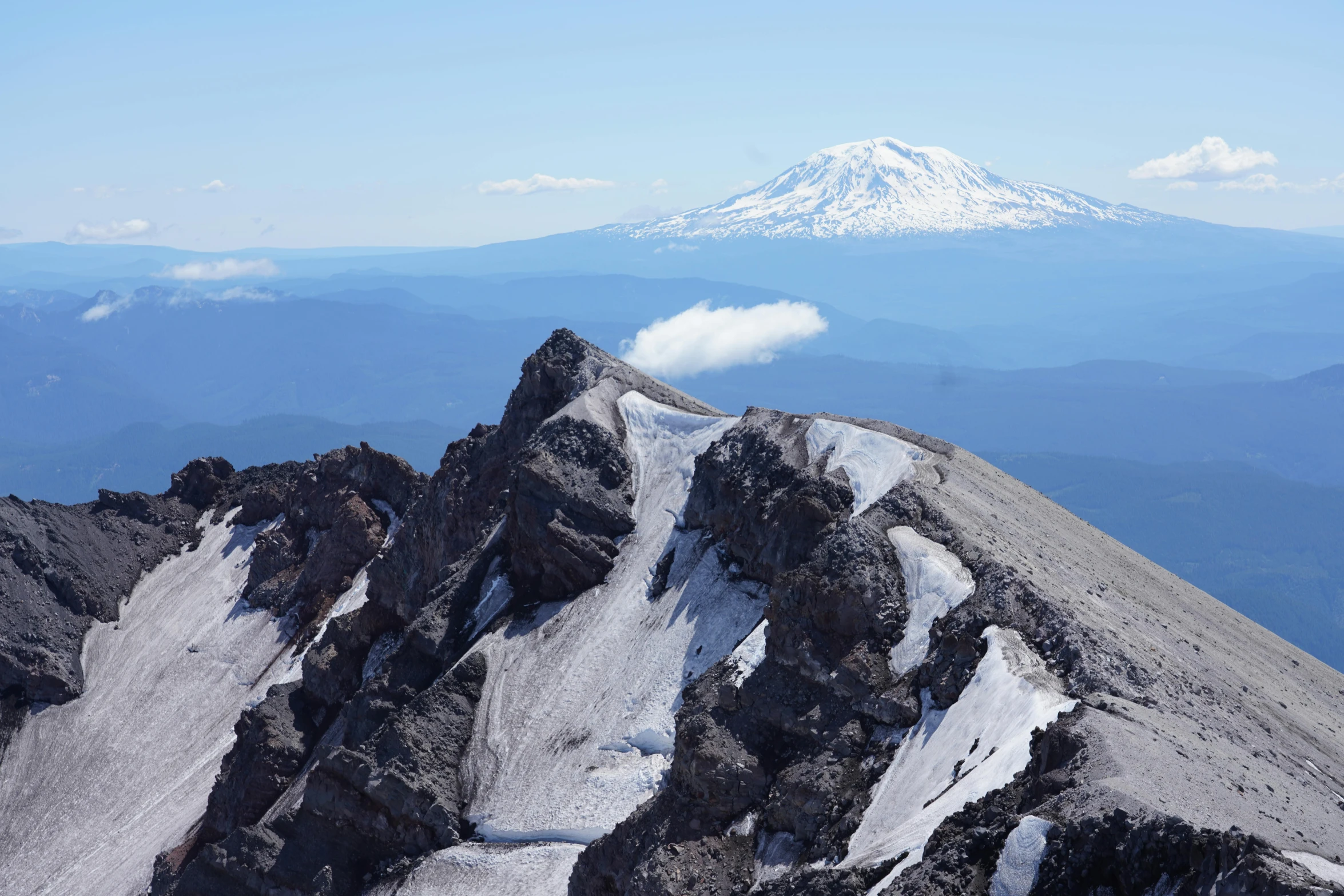 a snowy mountain range is seen with a snow capped mountain in the distance