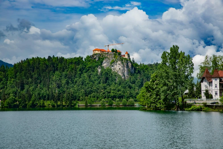 a castle on a hill next to a lake