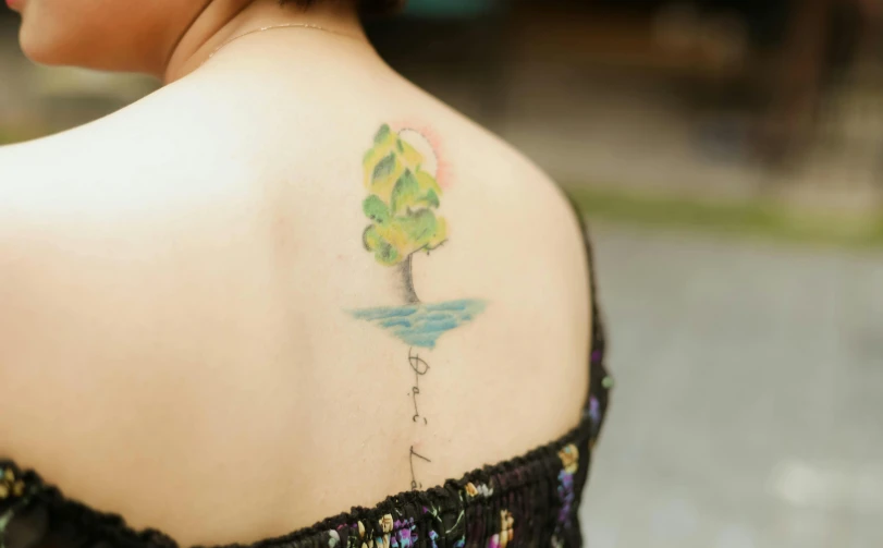 a girl with tattoos has a small tree on her back