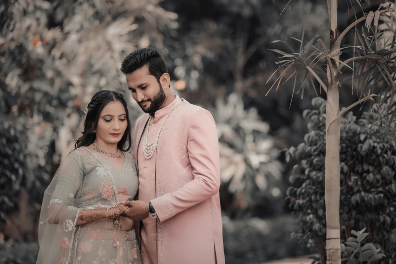 a man and woman dressed in wedding outfits looking at soing