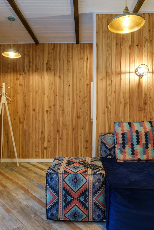 a room with a blue couch and wooden walls