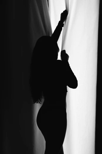 a woman that is standing near a curtain