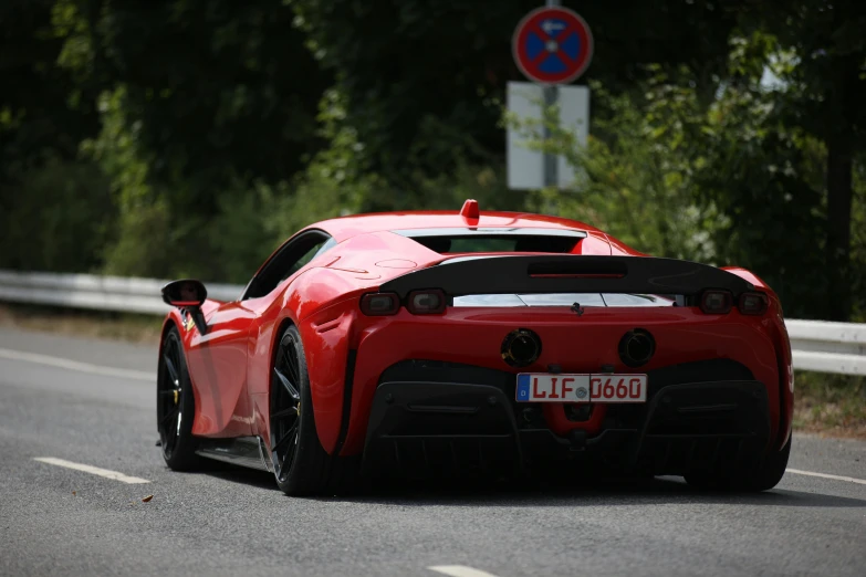 the car is on the road beside a street sign