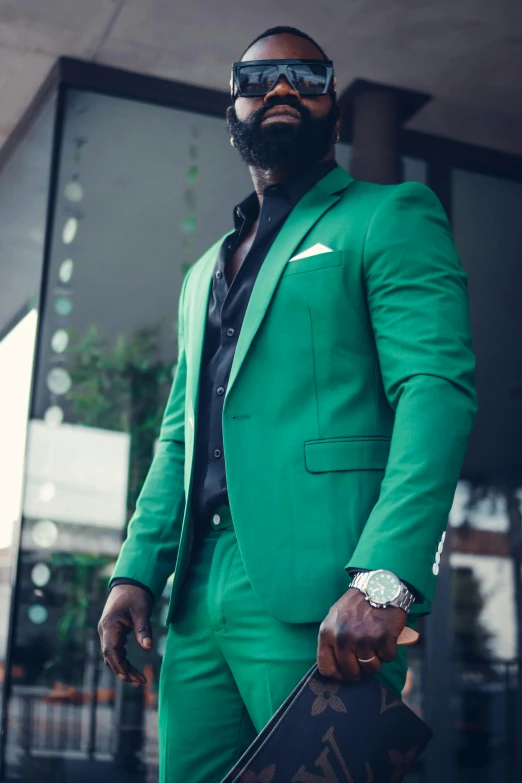 man wearing green suit standing outside the building