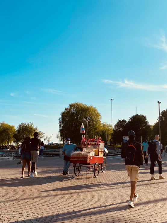 a group of people walk past the horse drawn carriage