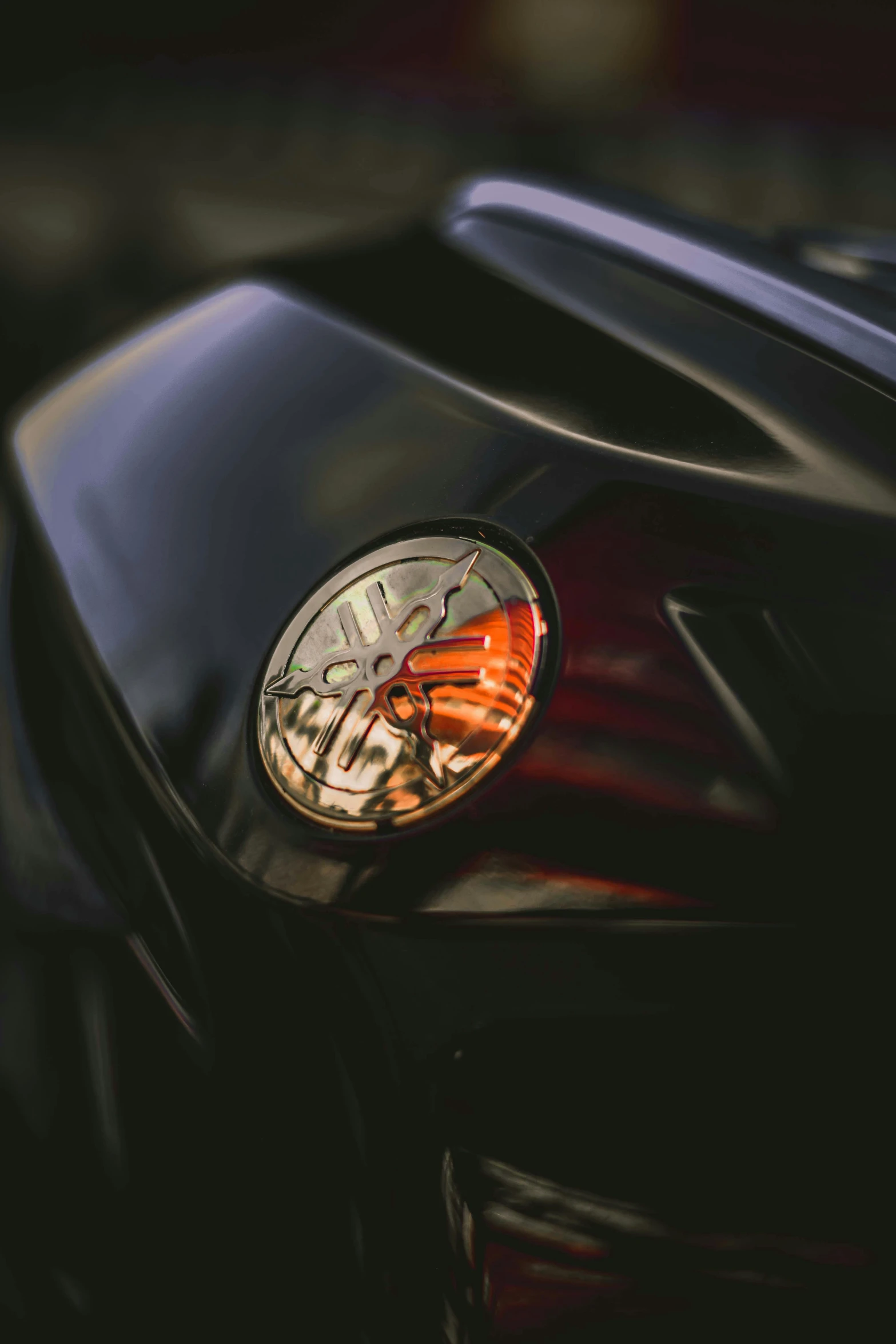 a red motorcycle with the headlights on, and an orange erfly logo