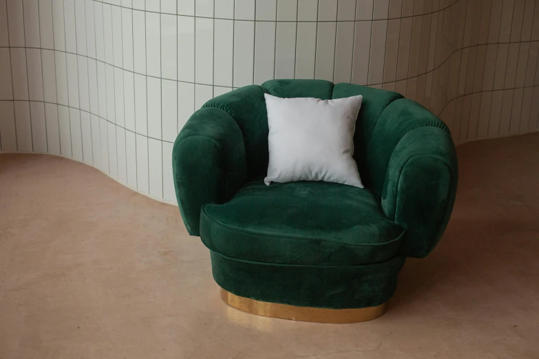 a green chair with white cushions sits in a room