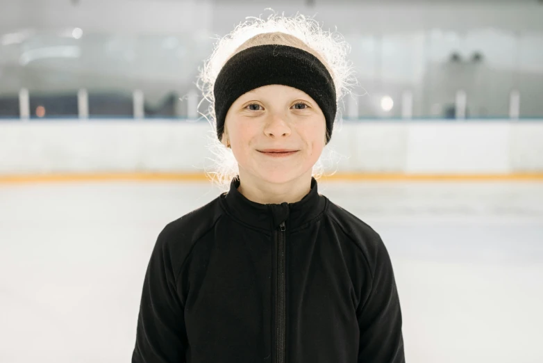 a little boy that has a black jacket and a beanie on