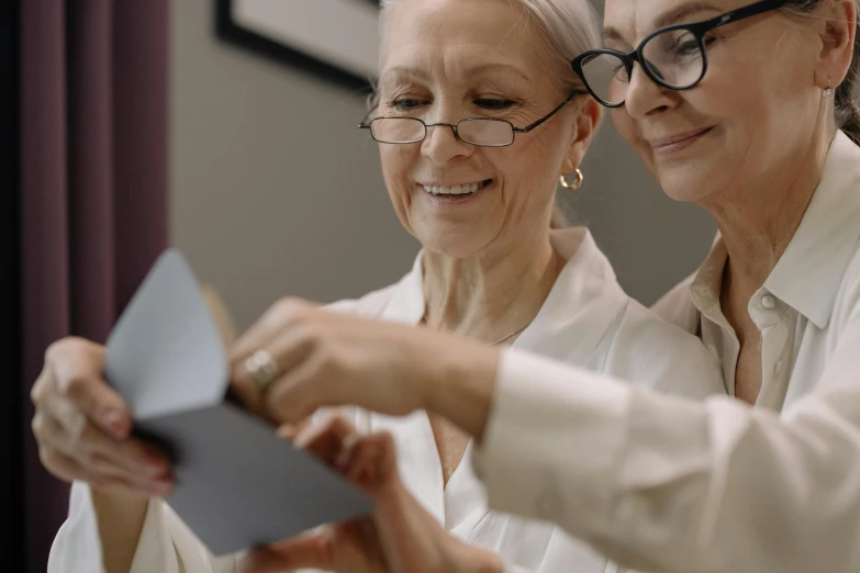 two women dressed in business attire, looking at a paper