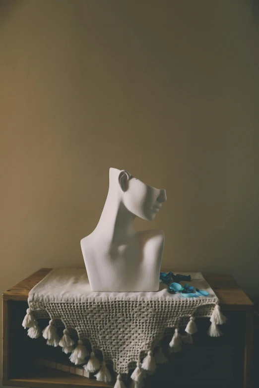 a white sculpture on a table and a piece of cloth