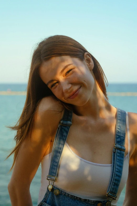 a woman with a denim overalls posing for a po