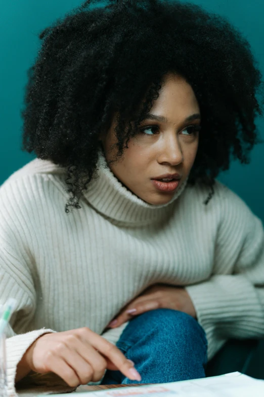 a woman sitting on a couch with curly hair