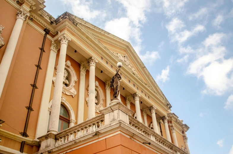 a large tan building with columns and clocks