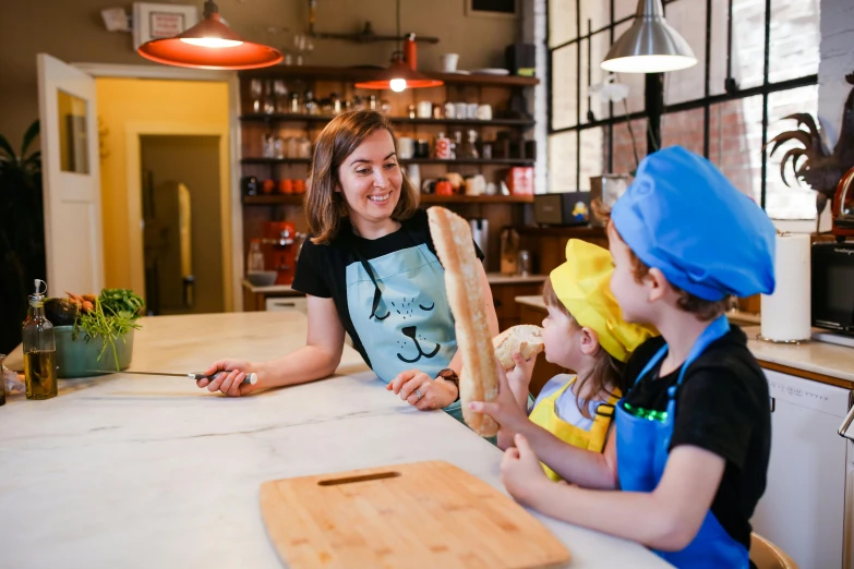 a woman holding some bread at the counter