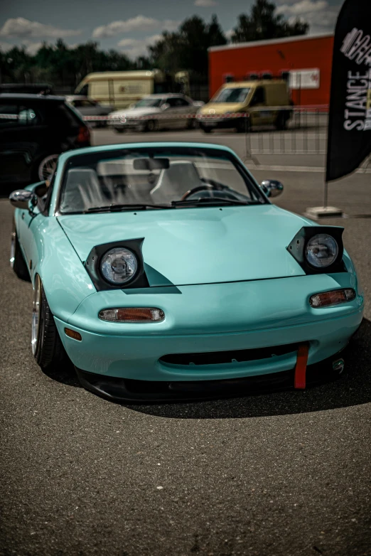 the front of a light blue sports car parked in a parking lot