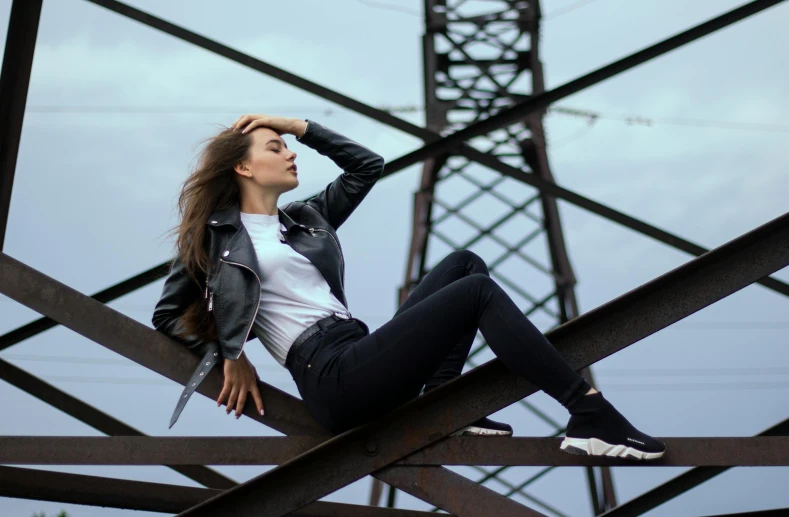 a woman is sitting on top of a steel structure