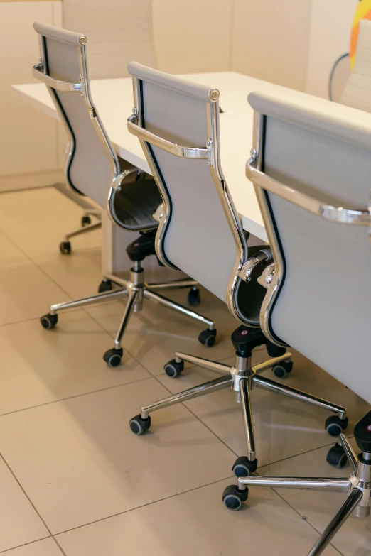 three chairs sit in front of a rectangular table