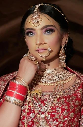 a woman wearing red clothing with gold jewelry on her face