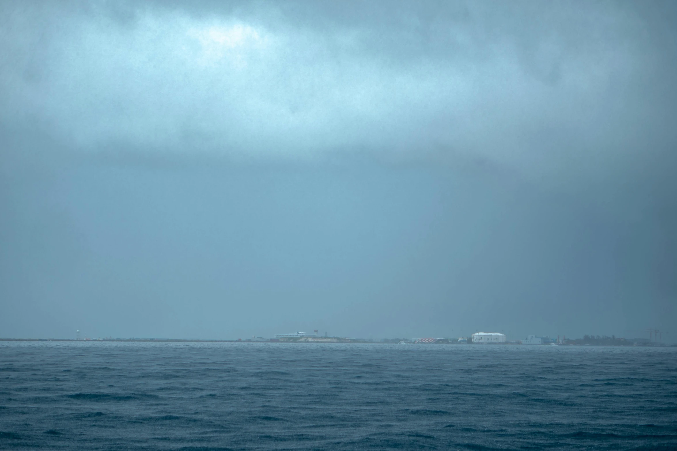 a distant view of an ocean with some buildings