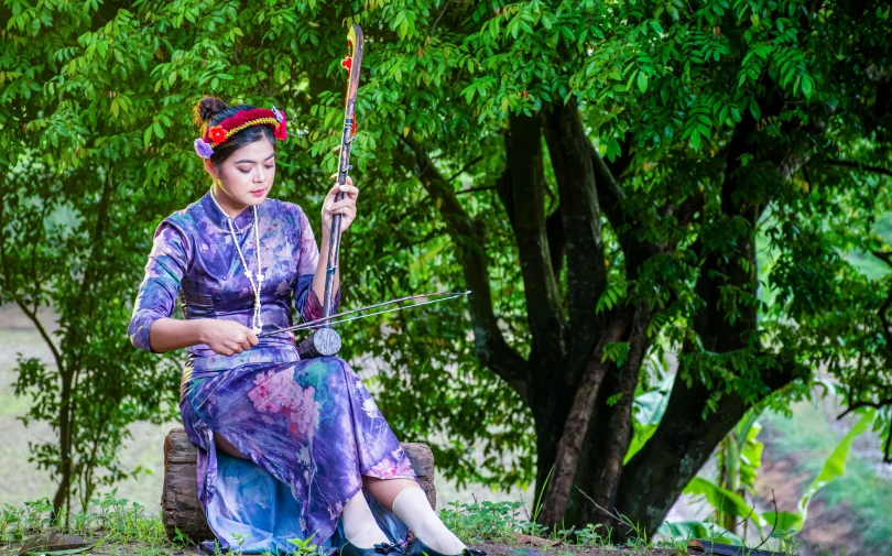 a woman sitting on a tree trunk next to some nches