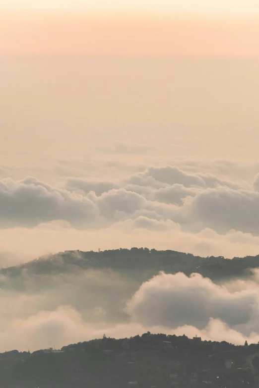 a large mountain with thick fog in the valley below