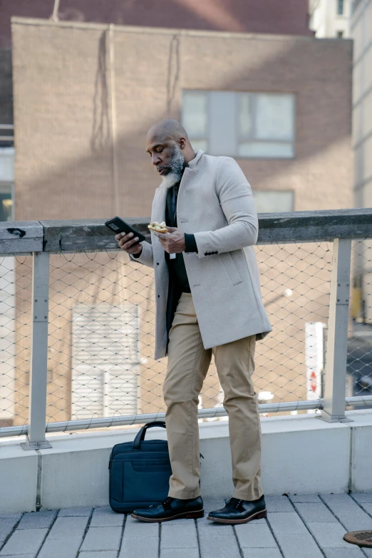 an old man is on the phone next to some building