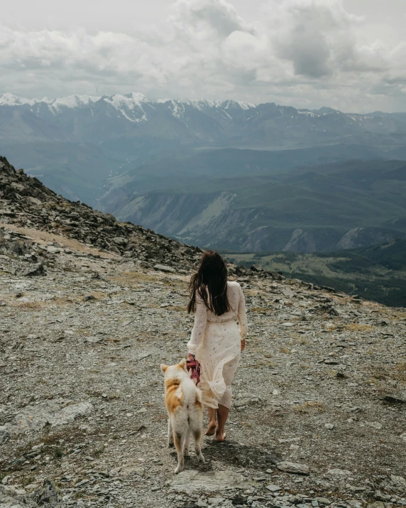 a woman walking on top of a dirt hill