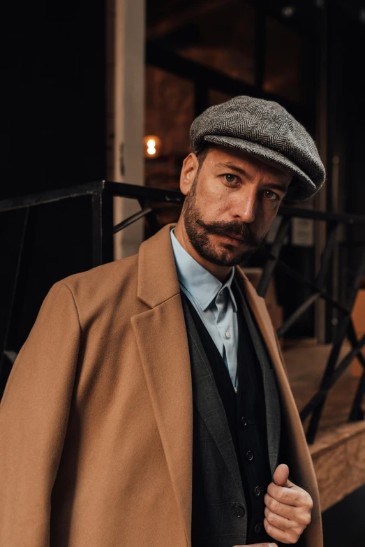 a man with a gray hat and jacket posing for a po