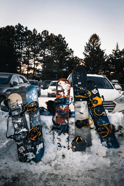 snowboards stuck up to one another in the snow