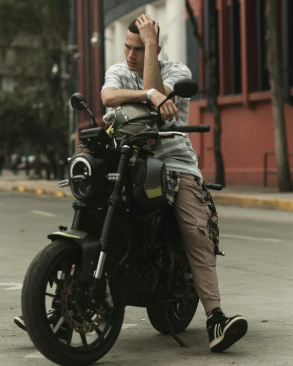 man sitting on the back of a motorcycle leaning against his seat