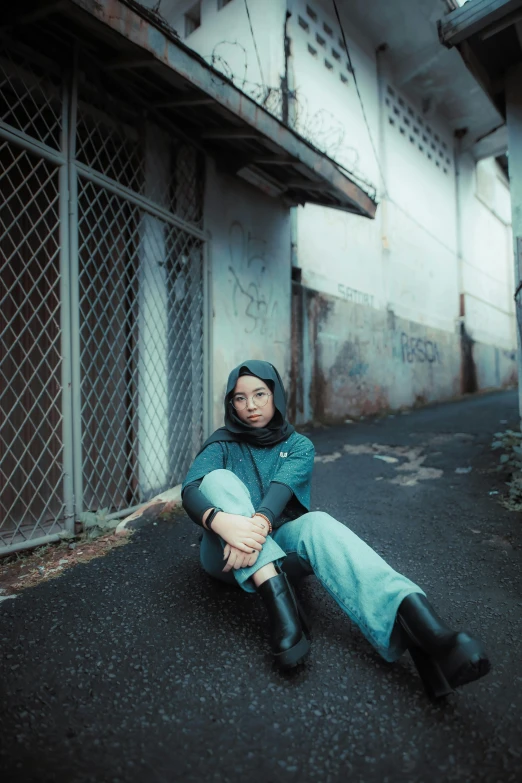 the woman is sitting on a black road