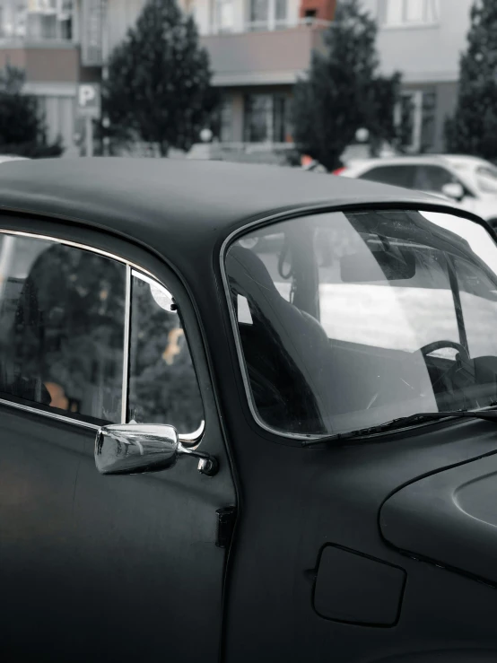 old timey looking black car parked in lot