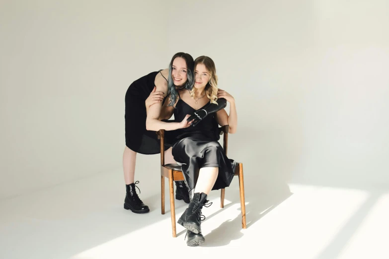 two women sitting on chairs in a studio