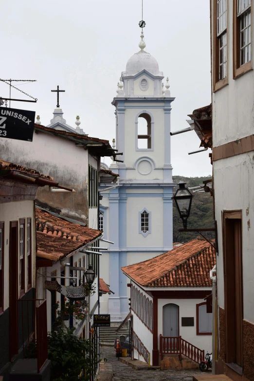 a tall church tower standing over an alleyway