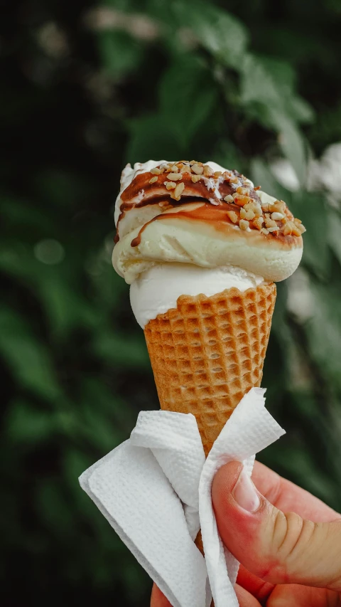 an ice cream cone is being held up by a person