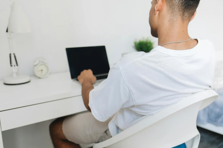 man sitting in an office chair working on a laptop