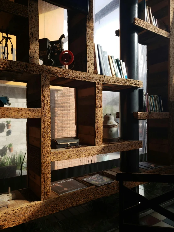 a tall wooden bookshelf holding a laptop, clock, and several books