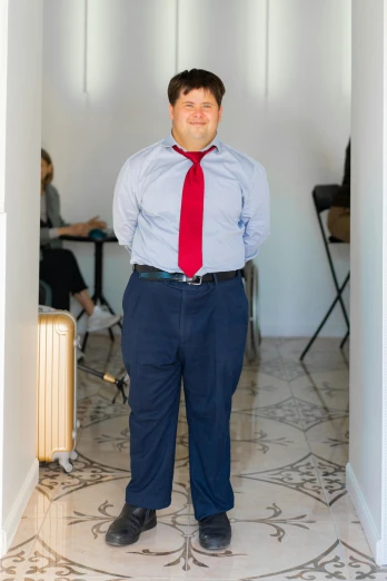 the man in a tie and dress shoes is standing inside a room
