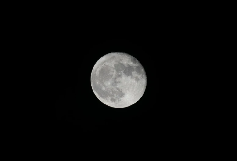 a black sky with a full moon in the distance