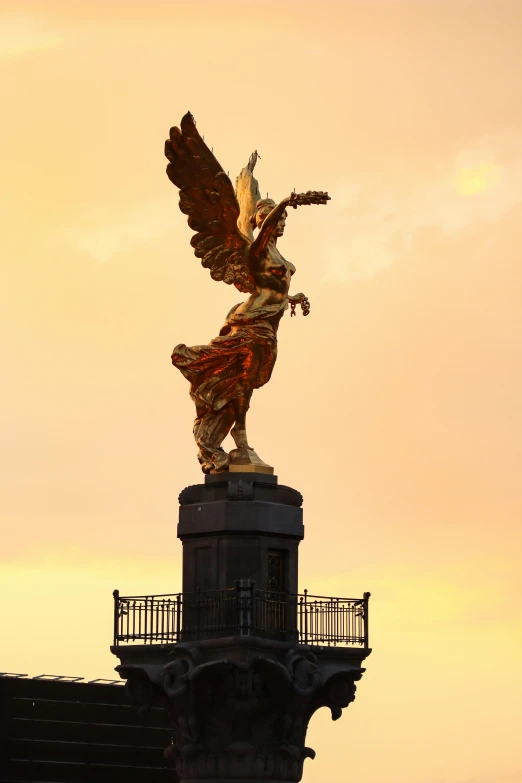 a large sculpture of a woman with wings on top of a building