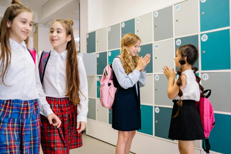 three girls standing by lockers and praying