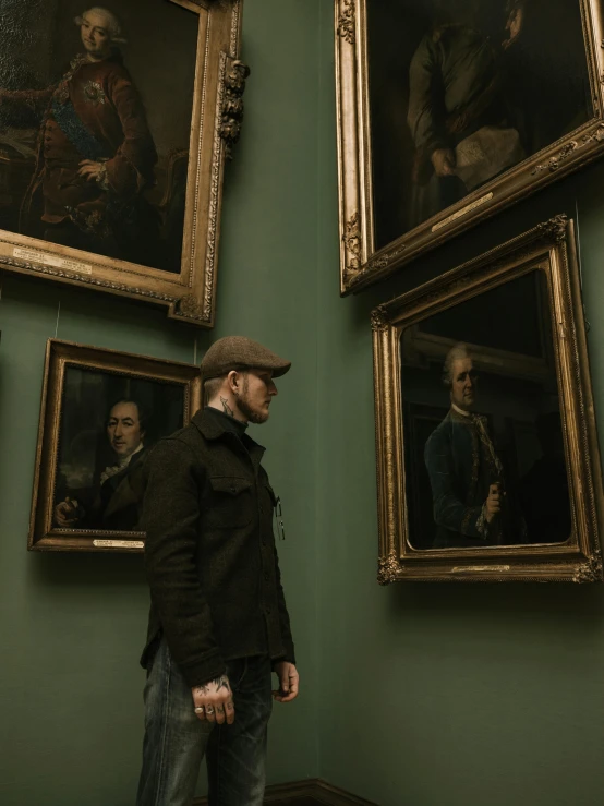 man standing in a museum in front of several paintings